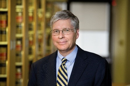 A photograph of a man in a white suit.