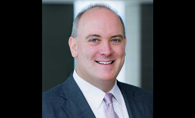 A photograph of a white man in a suit.