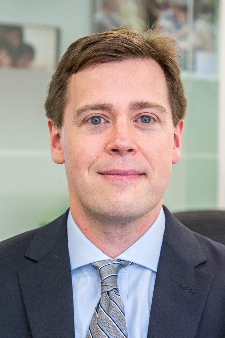 A photograph of a white man in a suit.