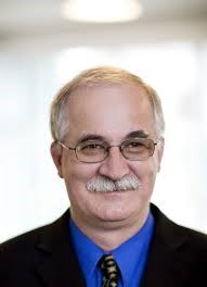 A photograph of a white man in a suit.