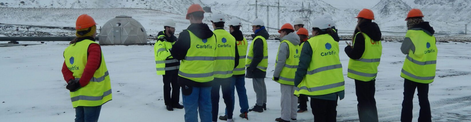 a group of Pitt students stand outside in yellow reflective vests in Iceland
